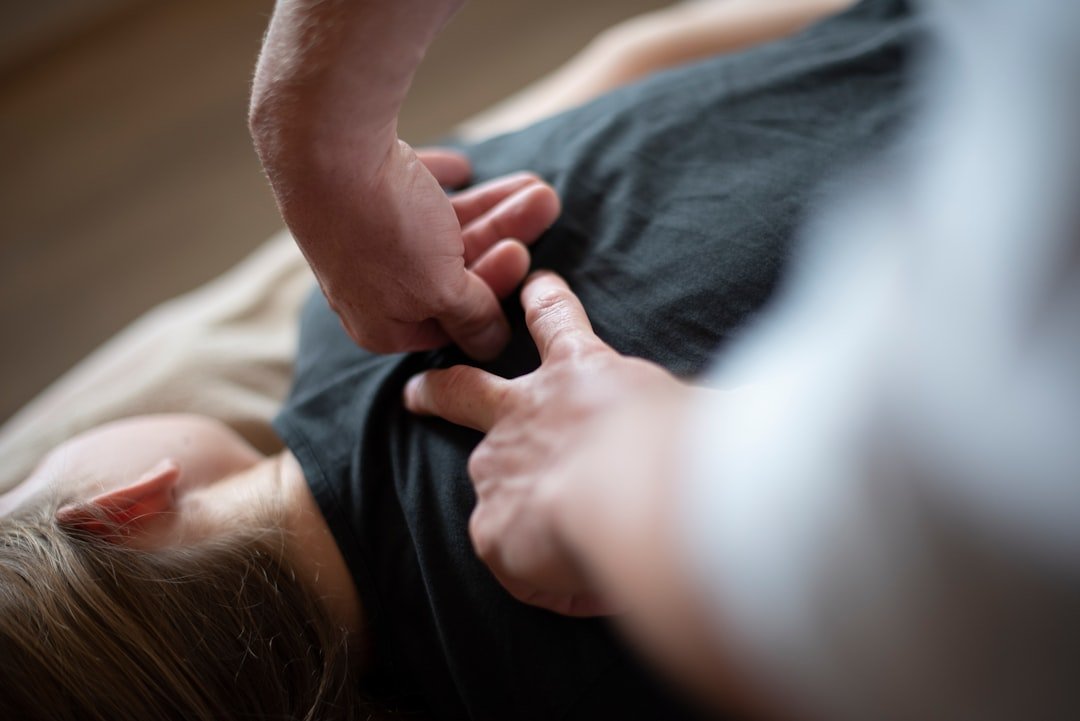 a-woman-laying-on-top-of-a-bed-holding-a-mans-hand-8qwya4invck